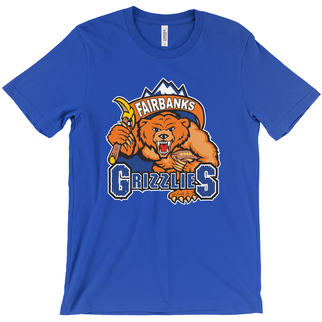 Fairbanks Grizzlies T-shirt. Royal Blue. Mountain peaks with brown banner with Fairbanks in white inside. Below, a growling bear, face on, holding a pick in his right arm and a football in his left over GRIZZLIES on blue with white trim. Royal Retros