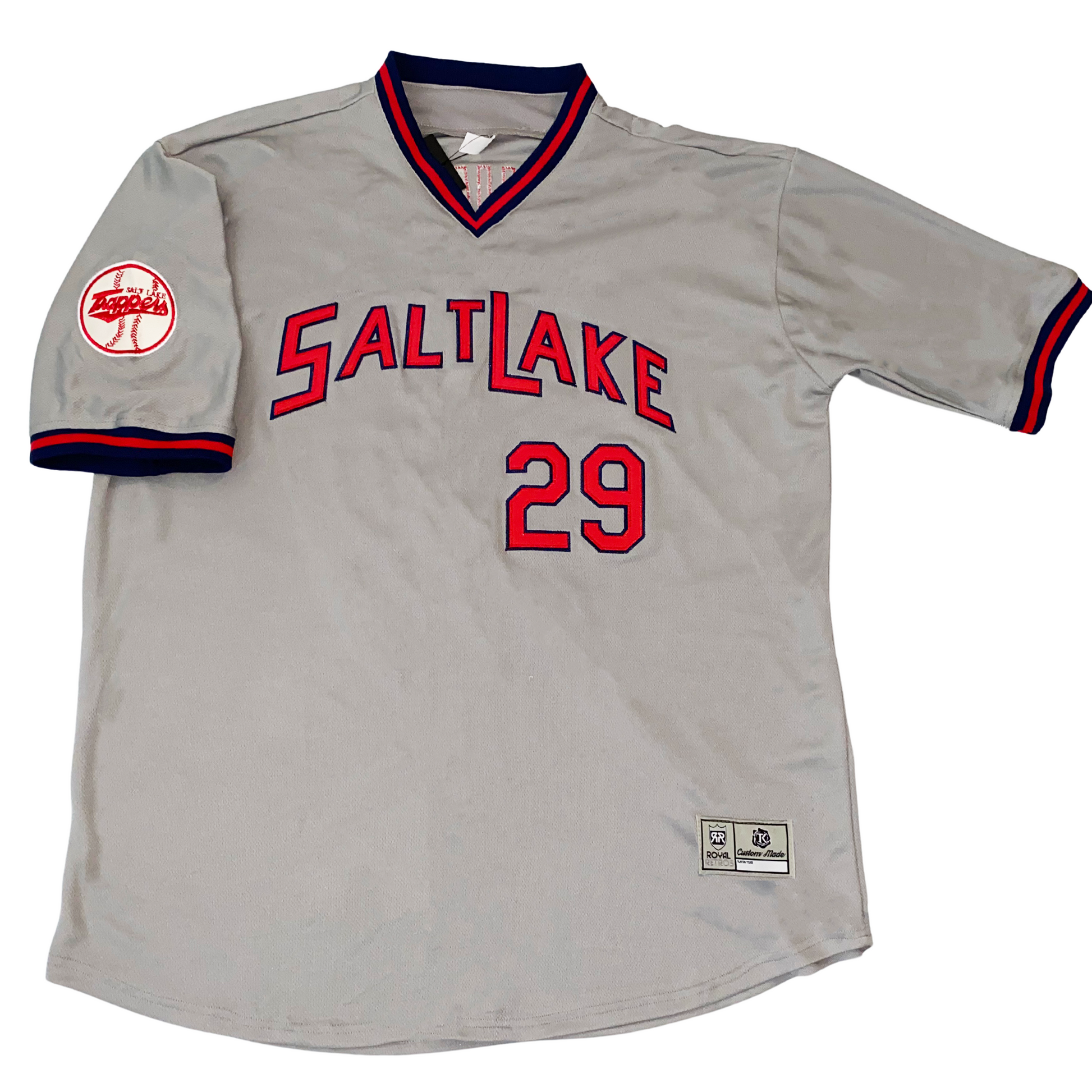 Salt Lake City Trappers baseball jersey gray, Blue, red, and blue collar and sleeve ends. Trappers baseball logo on sleeve. Salt Lake in red with blue trim arched across chest. #29 below right in red with blue trim. Royal Retros.