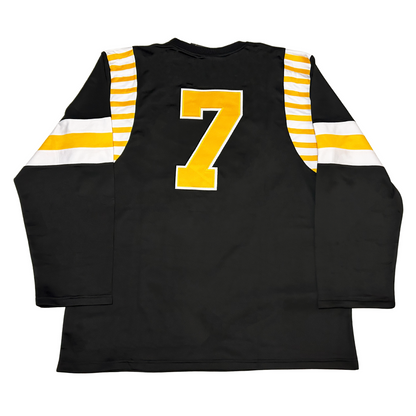 Atlantic Cats Roller Derby Jersey white. Alternating white and gold bars at shoulders. Thin white line, thick gold and, thin white line, mid-shoulder.  #7 in gold with white trim large on back. Royal Retros 