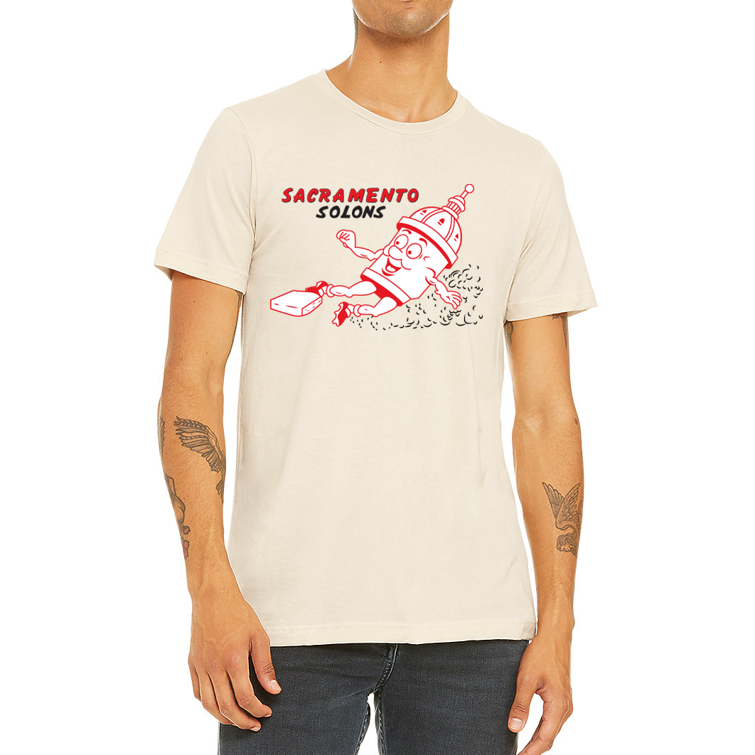 Sacramento Solons T-shirt. Natural. Sacramento in red, Solons in black below on right chest. Image of cartoon capital building, white with red detail, sliding into a base, right to left. Royal Retros