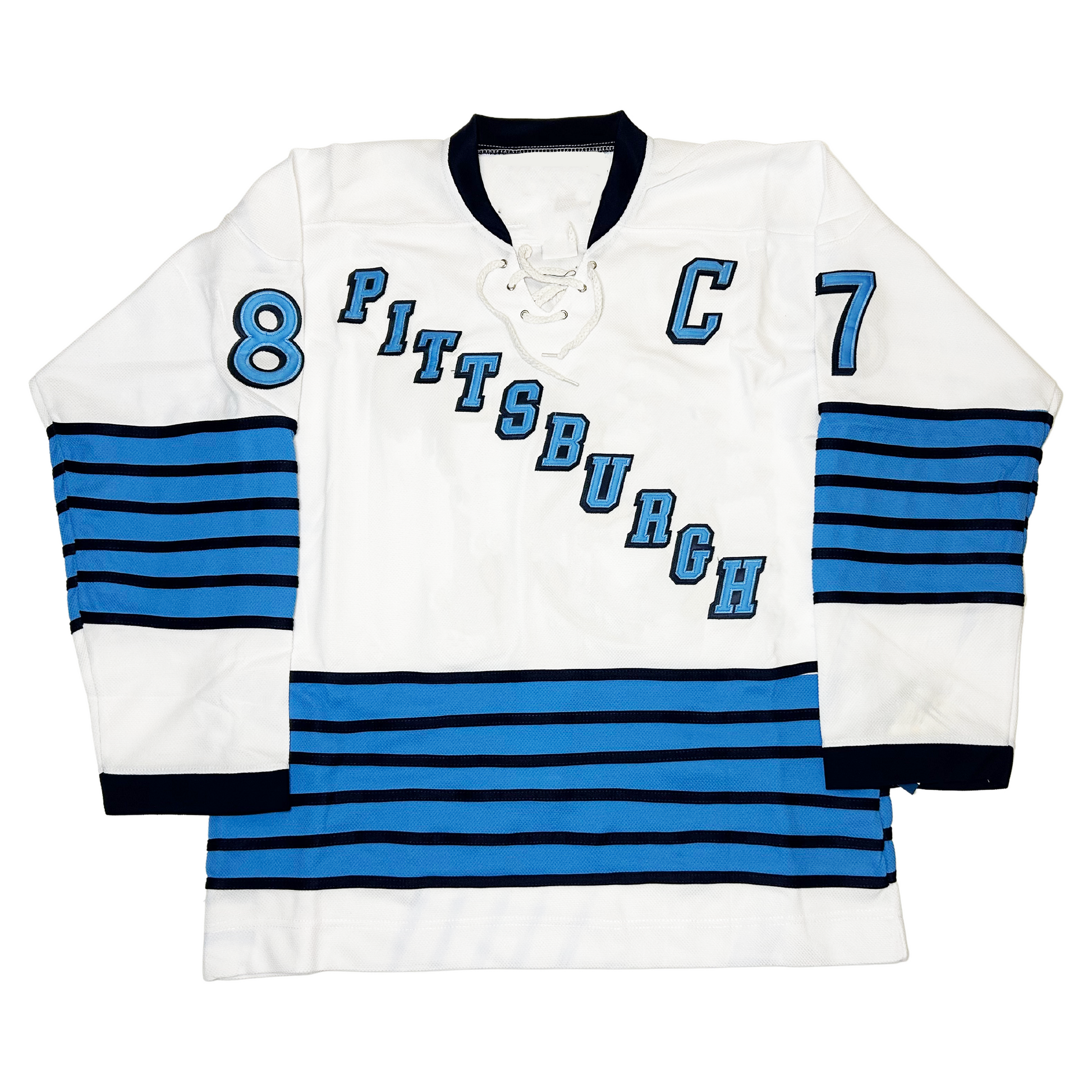 1967 Pittsburgh Penguins jersey. White. Black collar and sleeve ends. PITTSBURGH in blue diagonal top left to bottom right in blue with black trim. Thin black, thick blue alternating bands 5 times at mid-sleeve and around waist. #87 blue with black trim on upper sleeve. Captain's C blue with black trim on upper left chest. Royal Retros