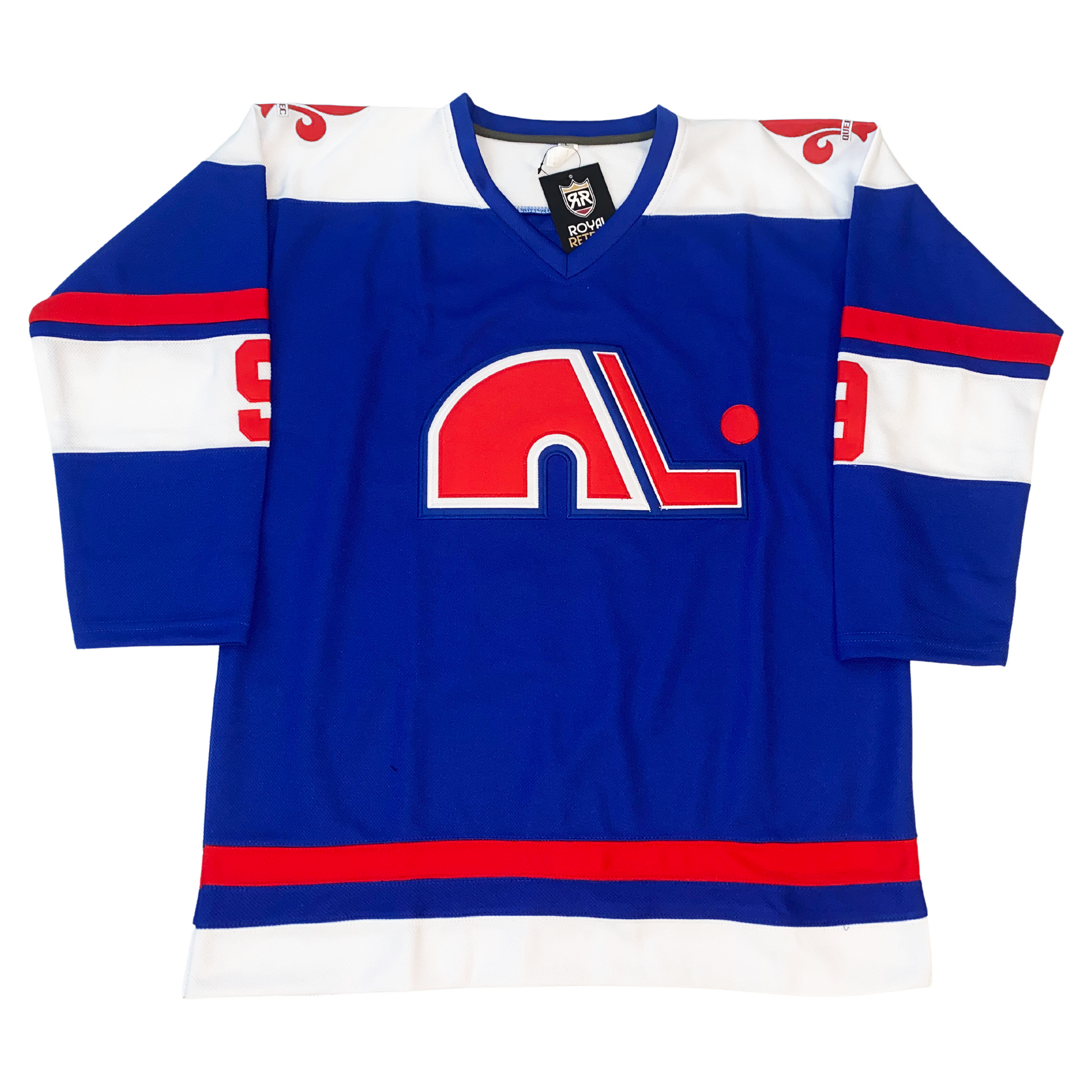 WHA Nordiques Jersey 1974 blue. White shoulders with red  fleur-de-lis. Blue collar. Red, blue, and larger white bands mid-sleeve. #9 in red in white band. Red, blue, and white band at waist. Lowercase N logo on chest in red with white trim. Red hockey stick to right of N with white trim, red puck above blade. Royal Retros