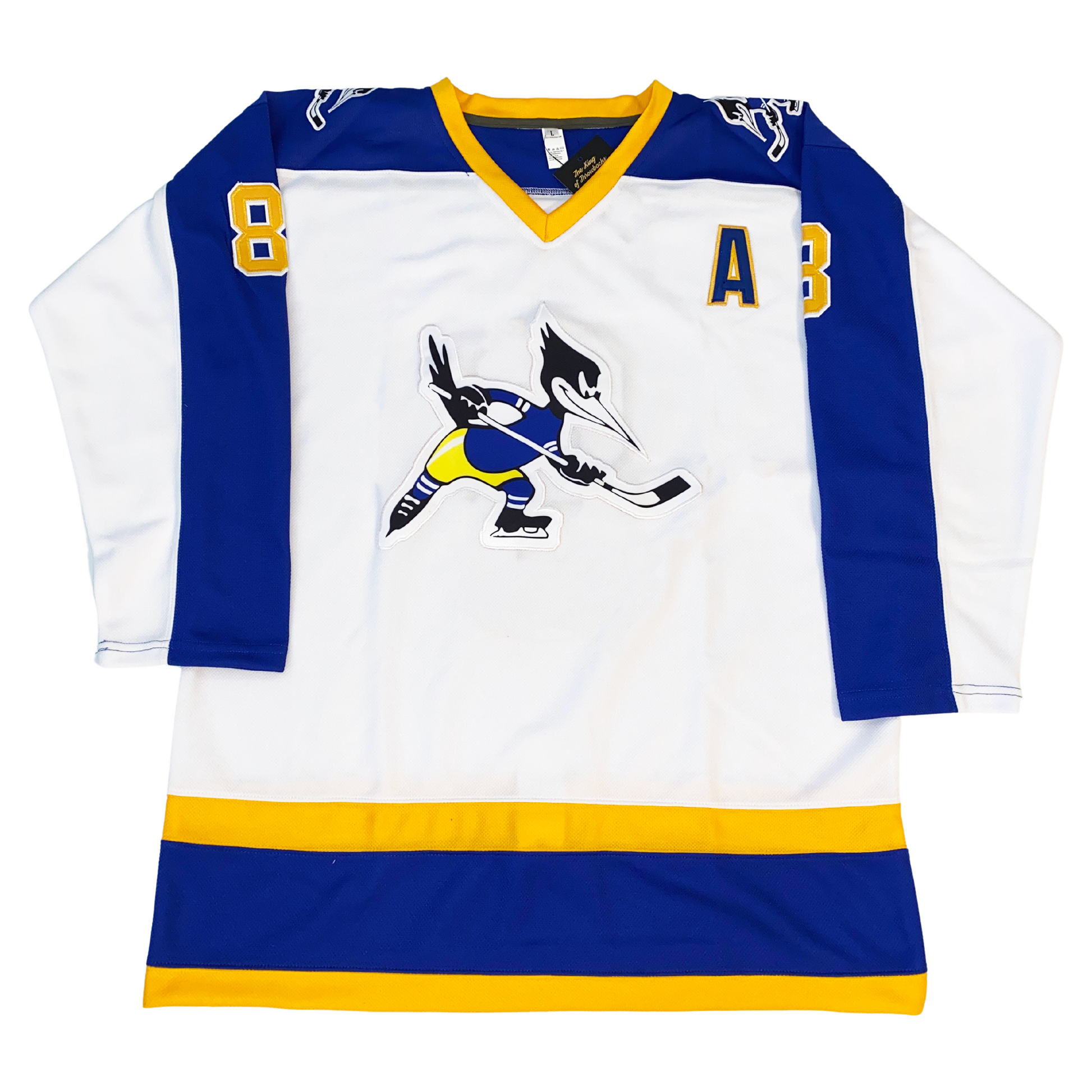 1974 Phoenix Roadrunners Jersey white with half blue sleeves. Gold blue and gold band on bottom. co-captain A in blue with gold trim on upper left chest. Roadrunner holding hockey stick large on chest, small on shoulders. Royal Retros