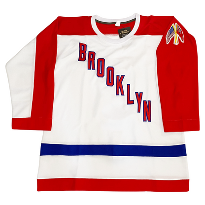 Brooklyn Americans hockey jersey. White. Red shoulders, half red sleeves. BROOKLYN diagonal down left to right. red with blue trim blue band above waist. red along waist. U.S. flag and old Canadian flag next to each other on left sleeve. Royal Retros