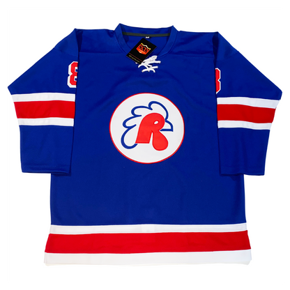 Providence Reds hockey jersey. Blue. White, red, white bands mid-sleeved and at waist. White circle in center with red trim, Letter R in red forming a rooster head. Blue beak and comb. #8 red with white trim on shoulders. Royal Retros