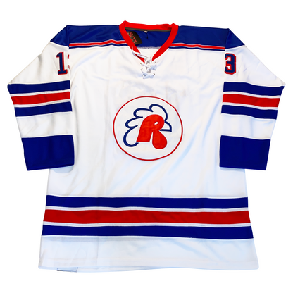 Providence Reds hockey jersey white. Blue, white, red, white, blue bands mid-sleeve and above waist. Blue sleeve ends. Blue shoulders with red trim and red collar. #13 blue with red trim on upper sleeves. Royal Retros